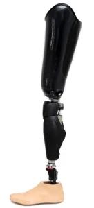 Photo d'une prothèse qui monte jusqu'à mi-cuisse. Elle est de couleur noire. Le pied de la prothèse à un effet naturel avec un pied de couleur beige. 