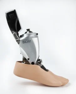 Photo d'une prothèse qui monte jusqu'en haut de la cheville. Elle est de couleur métal et a un pied de couleur beige. 
